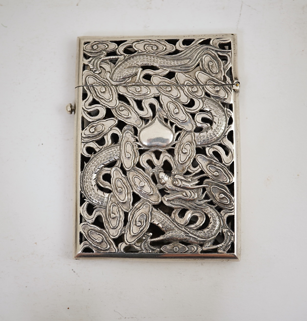 A late 19th century Chinese Export pierced silver card case, maker KMS(Kwong Man Shing), decorated with dragons amid clouds, 10.4cm, together with a Chinese Export pierced silver octagonal box and cover, by Luen Wo?, cir